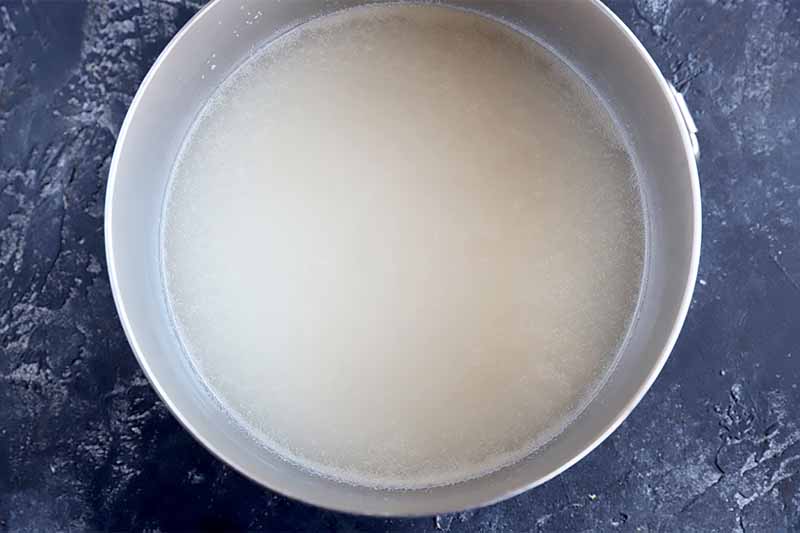 Horizontal image of a bowl with yeast dissolved in water.