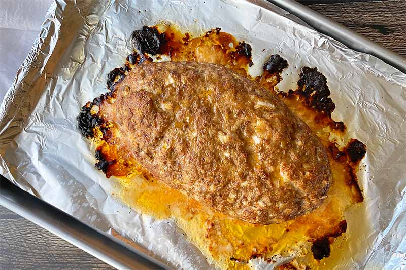 Horizontal image of a mound of cooked ground beef on foil.