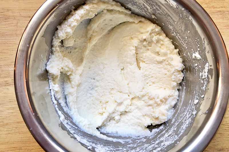 Horizontal image of a bowl filled with ricotta.