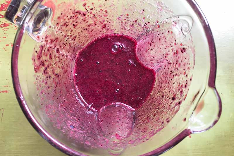 Horizontal image of blending a purple thick liquid.