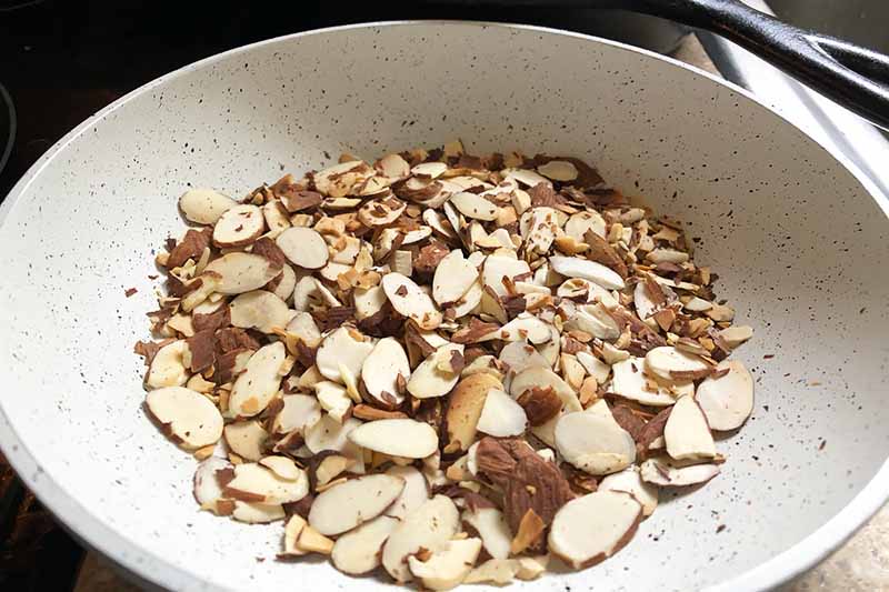 Horizontal image of a bowl of sliced toasted almonds.