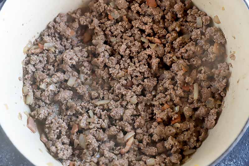 Horizontal image of cooked ground meat in a pot.