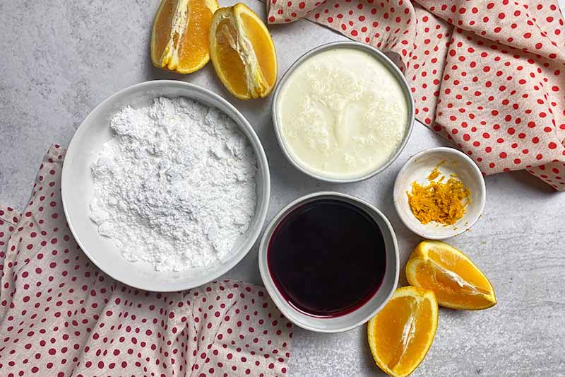 Horizontal image of bowls of powdered sugar, milk, juice, and orange zest.