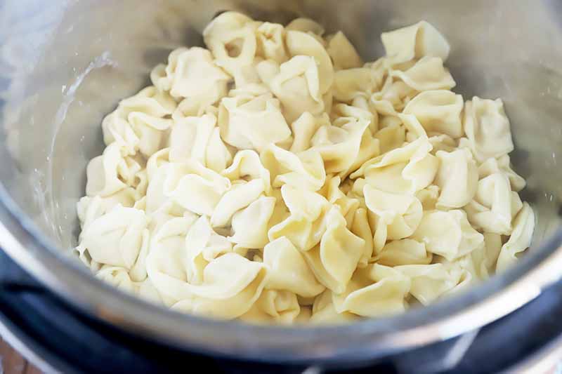 Horizontal image of a pot full of prepared stuffed pasta.