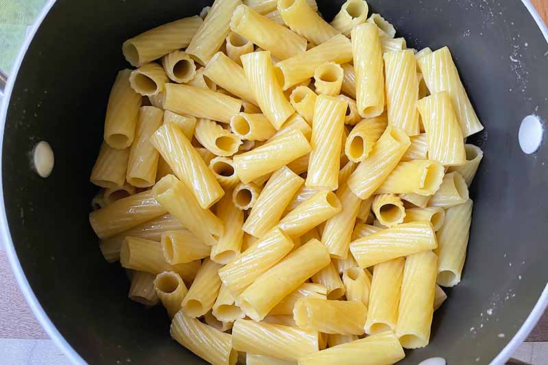 Horizontal image of cooked rigatoni in a pot.