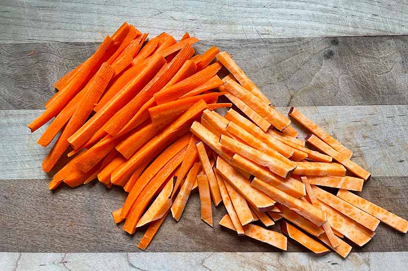 Horizontal image of carrot and sweet potato matchsticks.