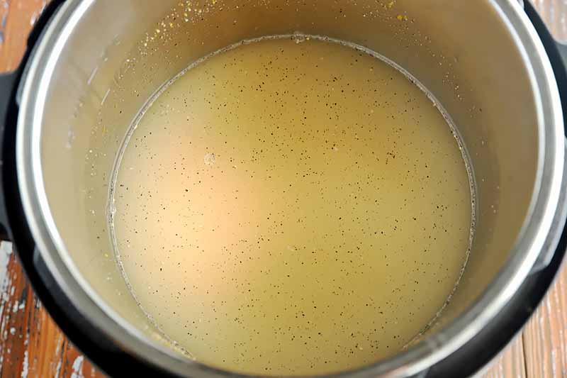 Horizontal image of water and yellow granules in a pot.