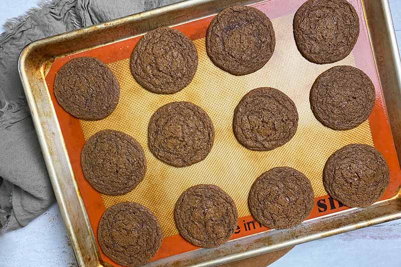 Horizontal image of light brown portioned baked goods on a baking sheet lined with a silicone mat.