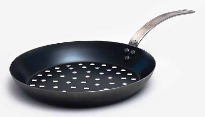 Image of a skillet with perforations on the bottom.