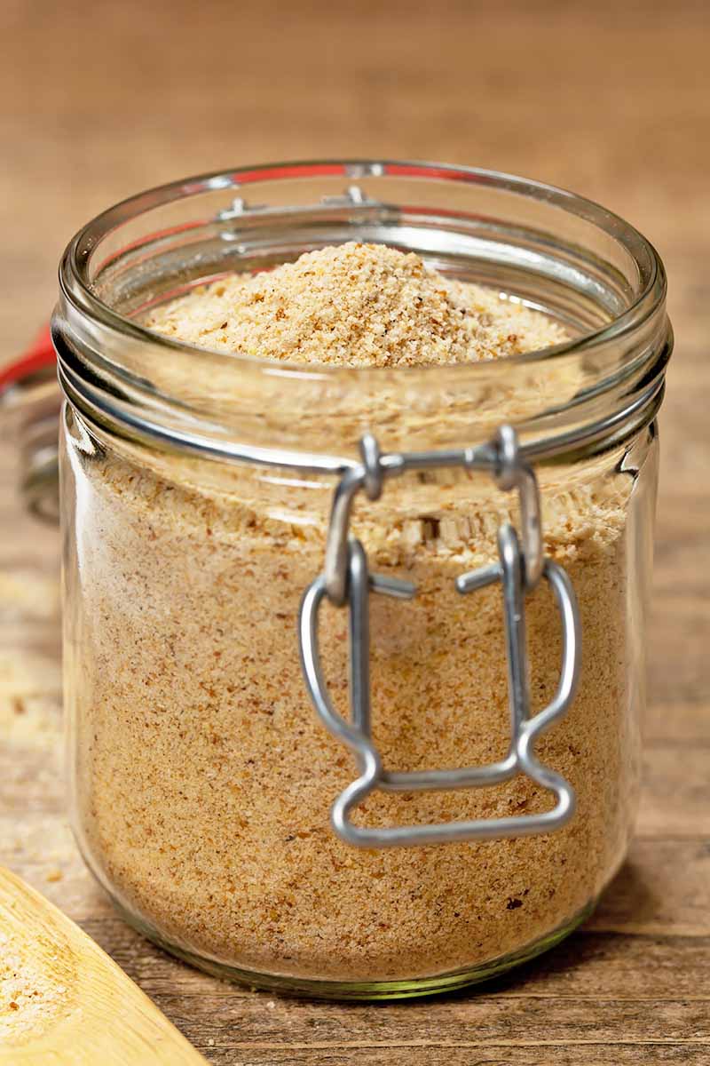 Vertical image of a glass jar filled with finely ground bread.