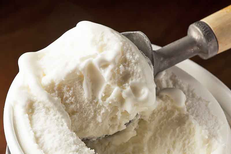 Horizontal image of scooping vanilla ice cream.