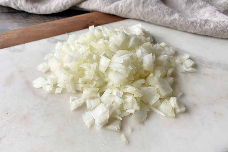 Horizontal image of a pile of chopped white onion.