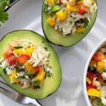 Horizontal image of avocado boats filled with a seafood and fruit salad.