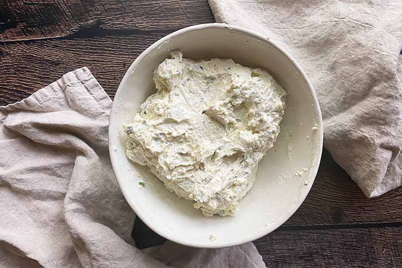 Horizontal image of a ricotta cheese mixture in a white bowl.
