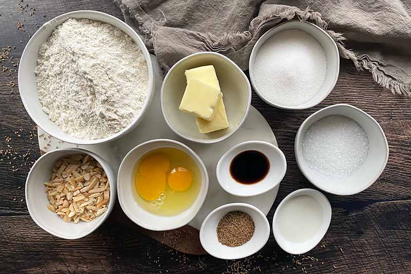 Horizontal image of assorted prepped ingredients in different sizes of white bowls.