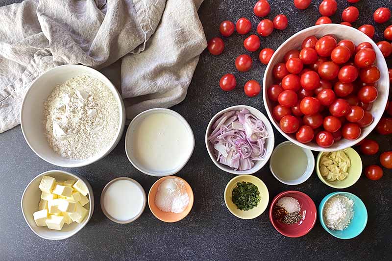 Horizontal image of various prepped dry, wet, and fresh ingredients in bowls.