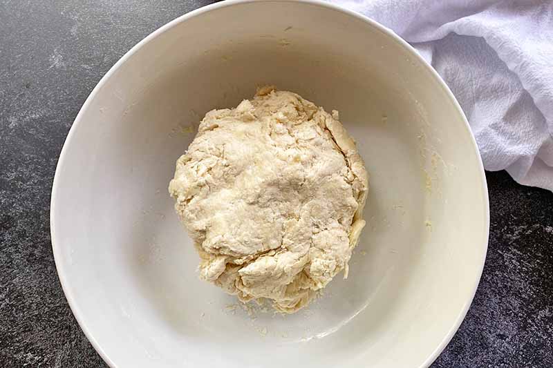 Horizontal image of a dough mixture in a large bowl.