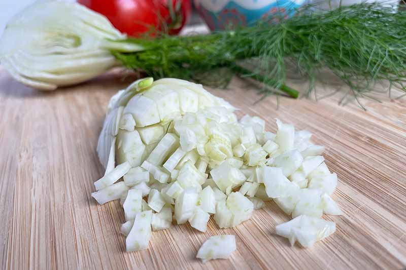 Horizontal image of diced fennel on a cutting board.