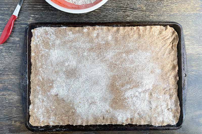 Horizontal image of dough pressed into a sheet pan.