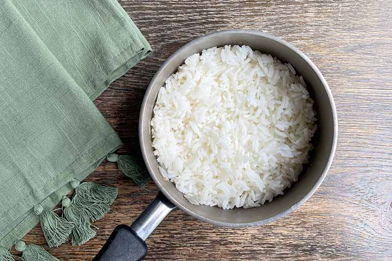 Horizontal image of cooked white rice in a pot.
