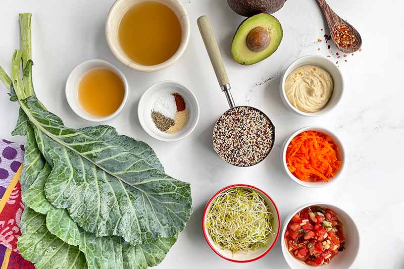 Horizontal image of assorted ingredients and condiments in bowls next to collard greens.