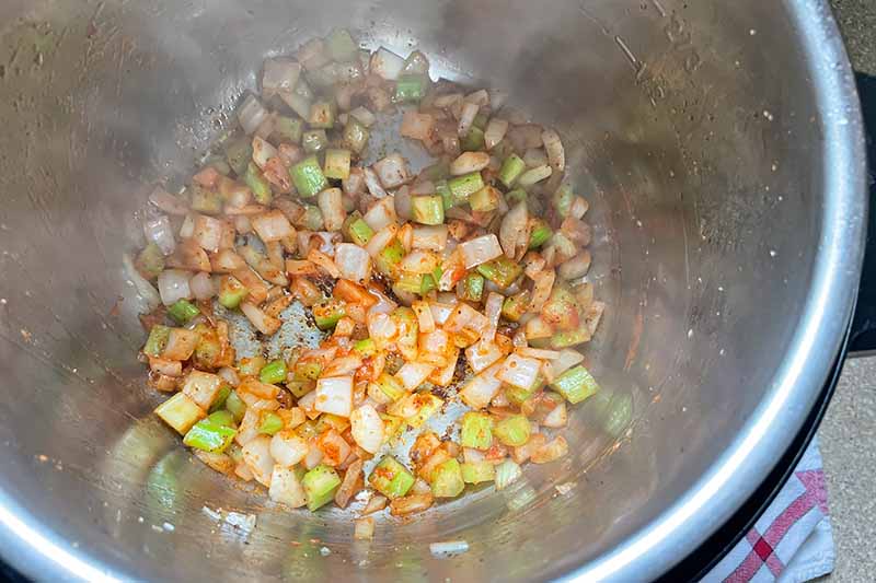 Horizontal image of cooking aromatics in a pot.