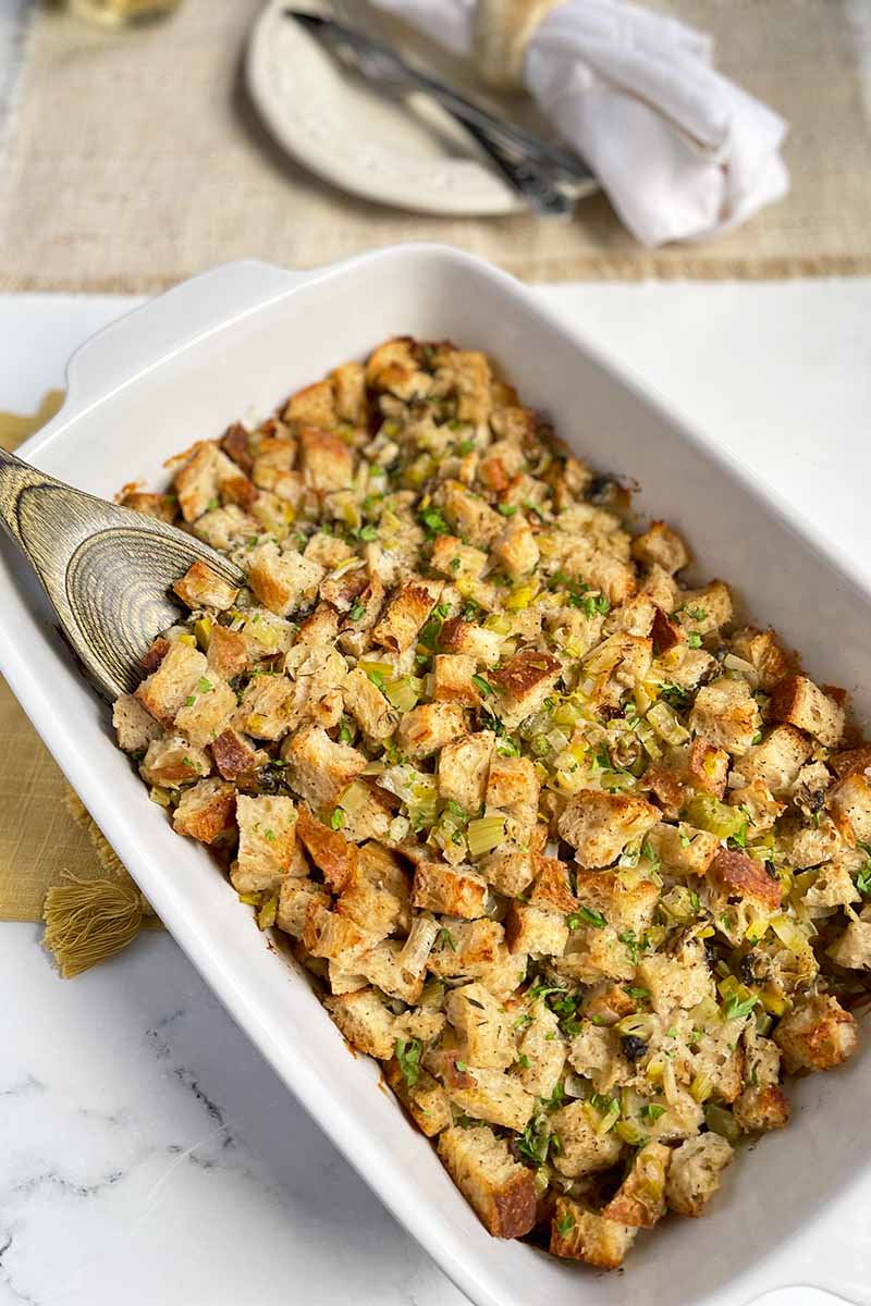 Vertical image of a white casserole dish filled with stuffing.
