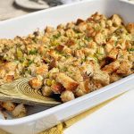 Horizontal image of a white casserole dish filled with a bread stuffing.