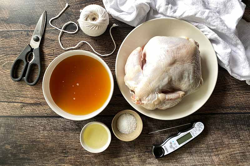 Horizontal image of equipment and ingredients to make a roasted poultry.