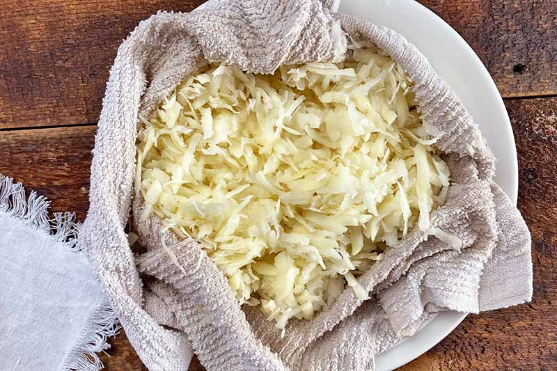 Horizontal image of grated potatoes in a towel.