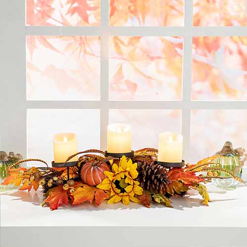 Image of a fall-themed candle holder on a window sill.