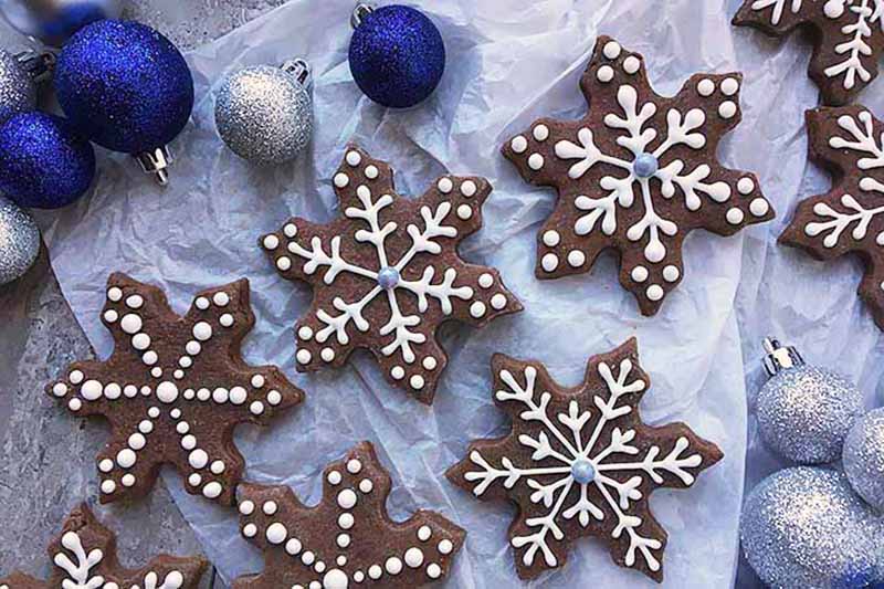 Image of assorted snowflake chocolate cookies next to decorations.