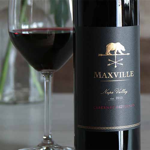 Horizontal image of the Maxville Lake Winery Cabernet Sauvignon bottle, with a glass next to it.