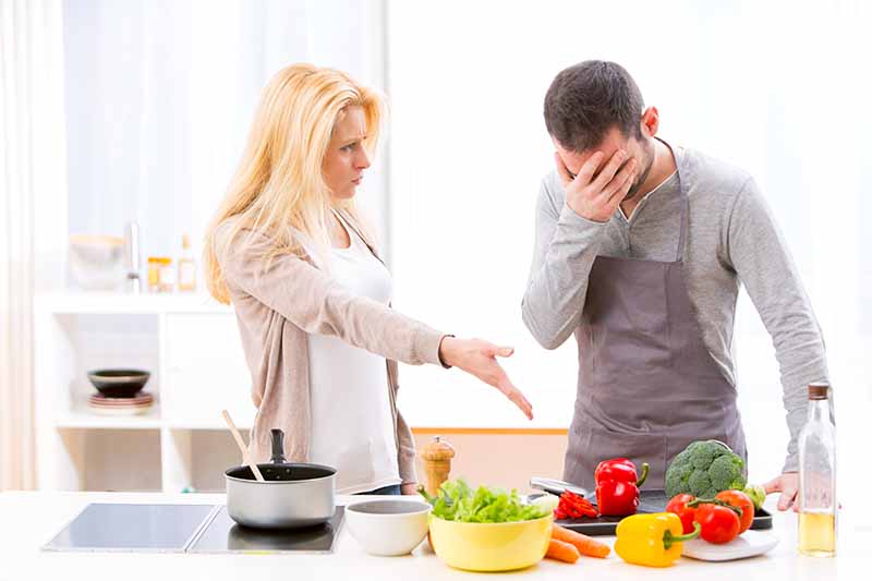 Horizontal image of a woman berating a man over vegetables.