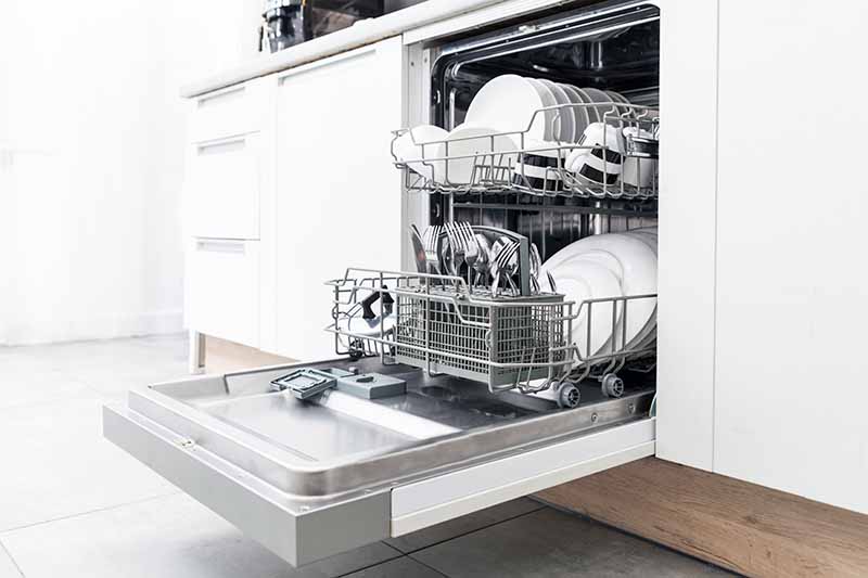 Horizontal image of a full dishwasher in a home kitchen.