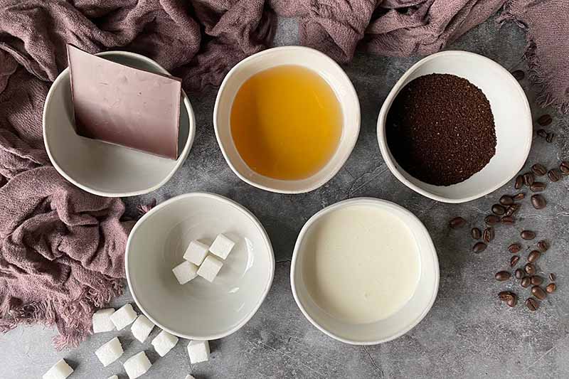 Horizontal image of measured ingredients in white bowls next to sugar cubes.