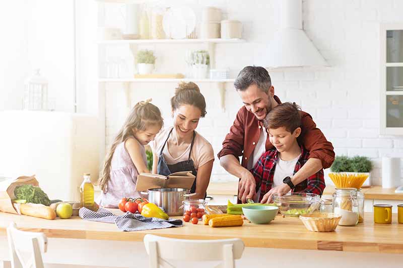 Horizontal image of a whole family making food together.