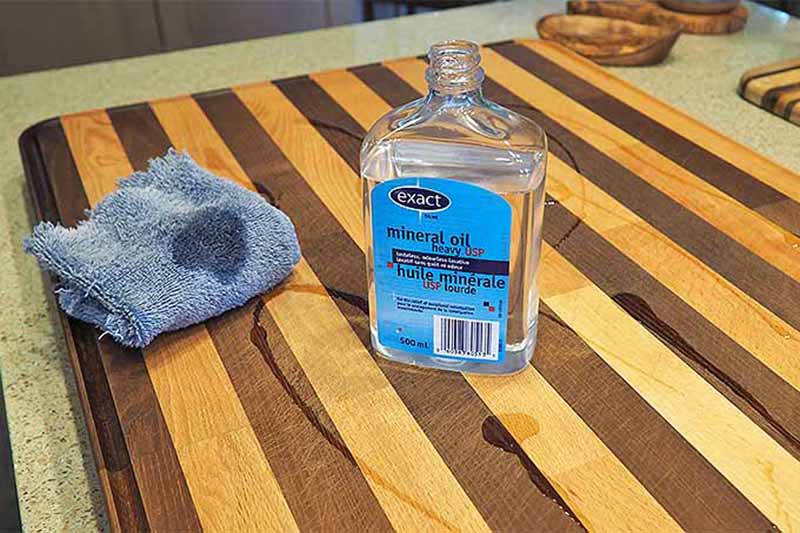 Horizontal image of applying mineral oil to a work surface with a rag.