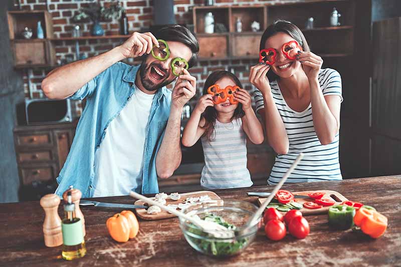 Horizontal image of a family having fun with vegetables.