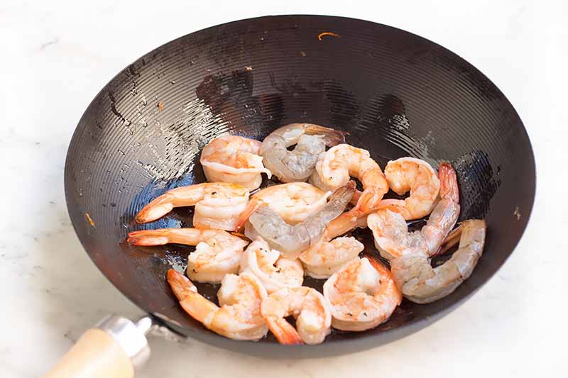 Horizontal image of cooking shrimp in a pan.