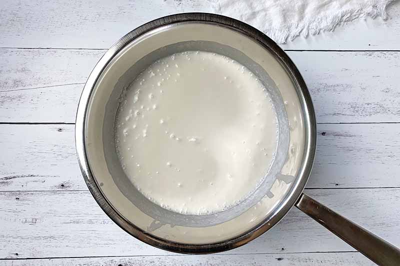 Horizontal image of heating coconut milk in a double boiler.