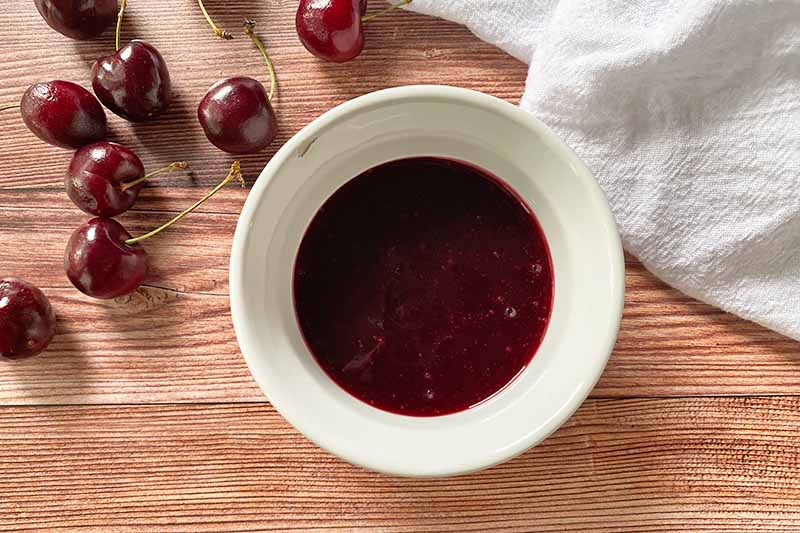 Horizontal image of a dark red liquid in a white bowl.