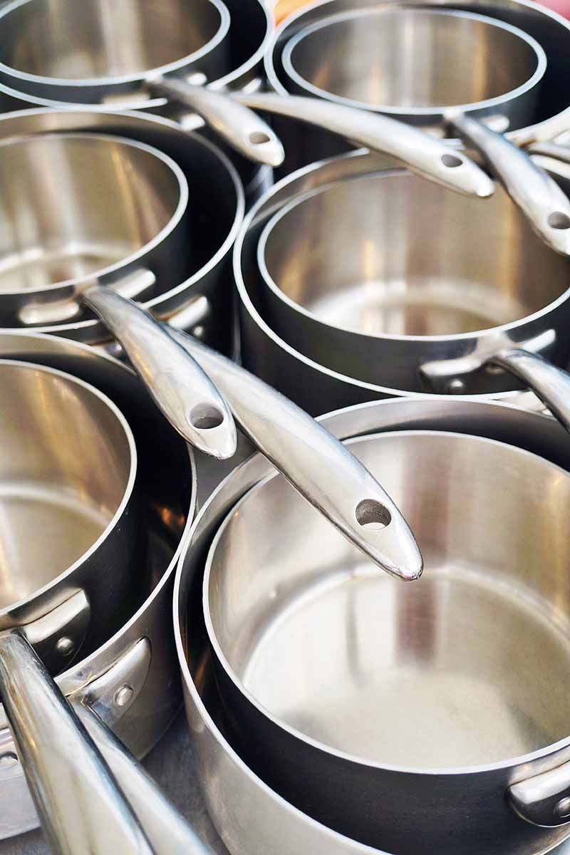 Vertical image of stainless steel kitchen equipment with long handles.