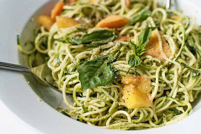 Horizontal image of pumpkin seed pesto with zucchini noodles in a bowl.