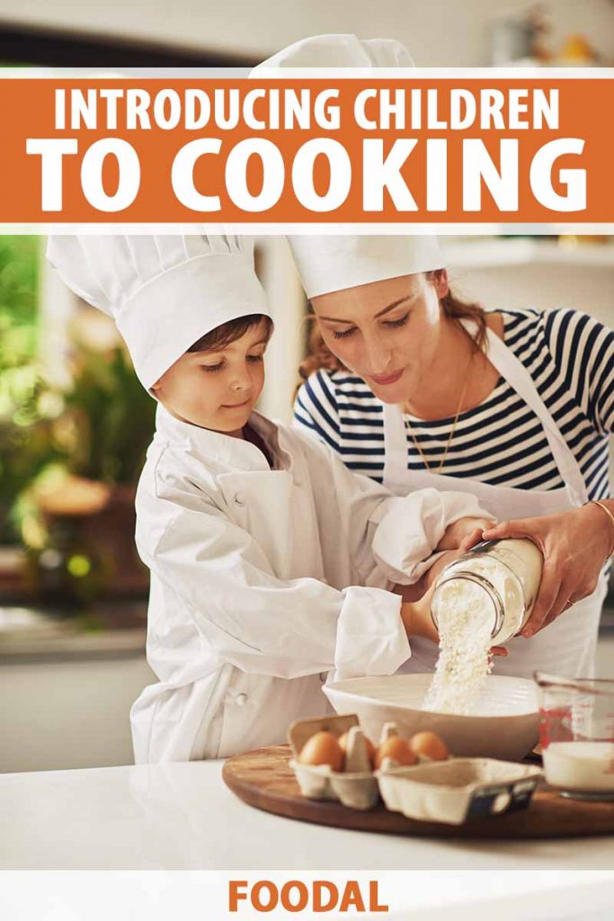 Vertical image of a mom and son baking something together, while wearing chef's hats and aprons.