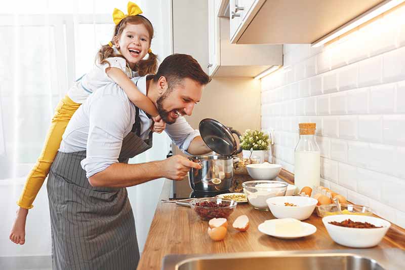 Horizontal image of a father and daughter having fun while baking.