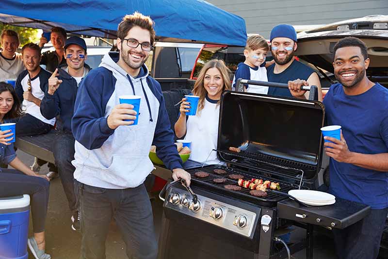 Horizontal image of a group of fans tailgating.
