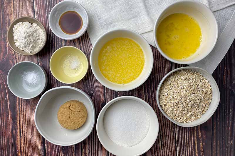 Horizontal image of assorted wet and dry ingredients measured out in small bowls.