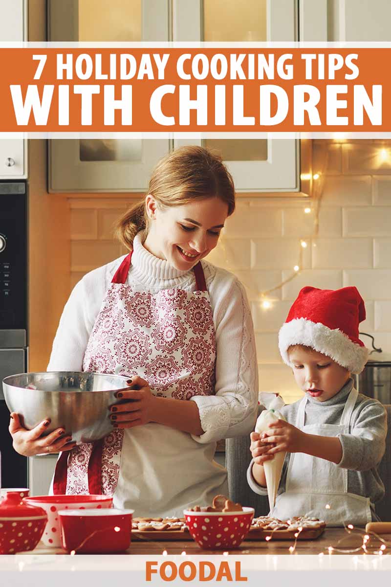 Vertical image of a mom and son decorating cookies together with a Christmas theme.