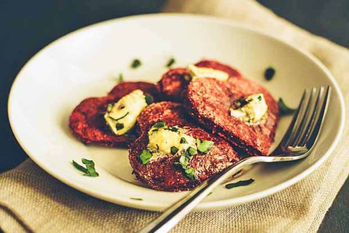 Horizontal image of heart-shaped patties topped with an herb butter.